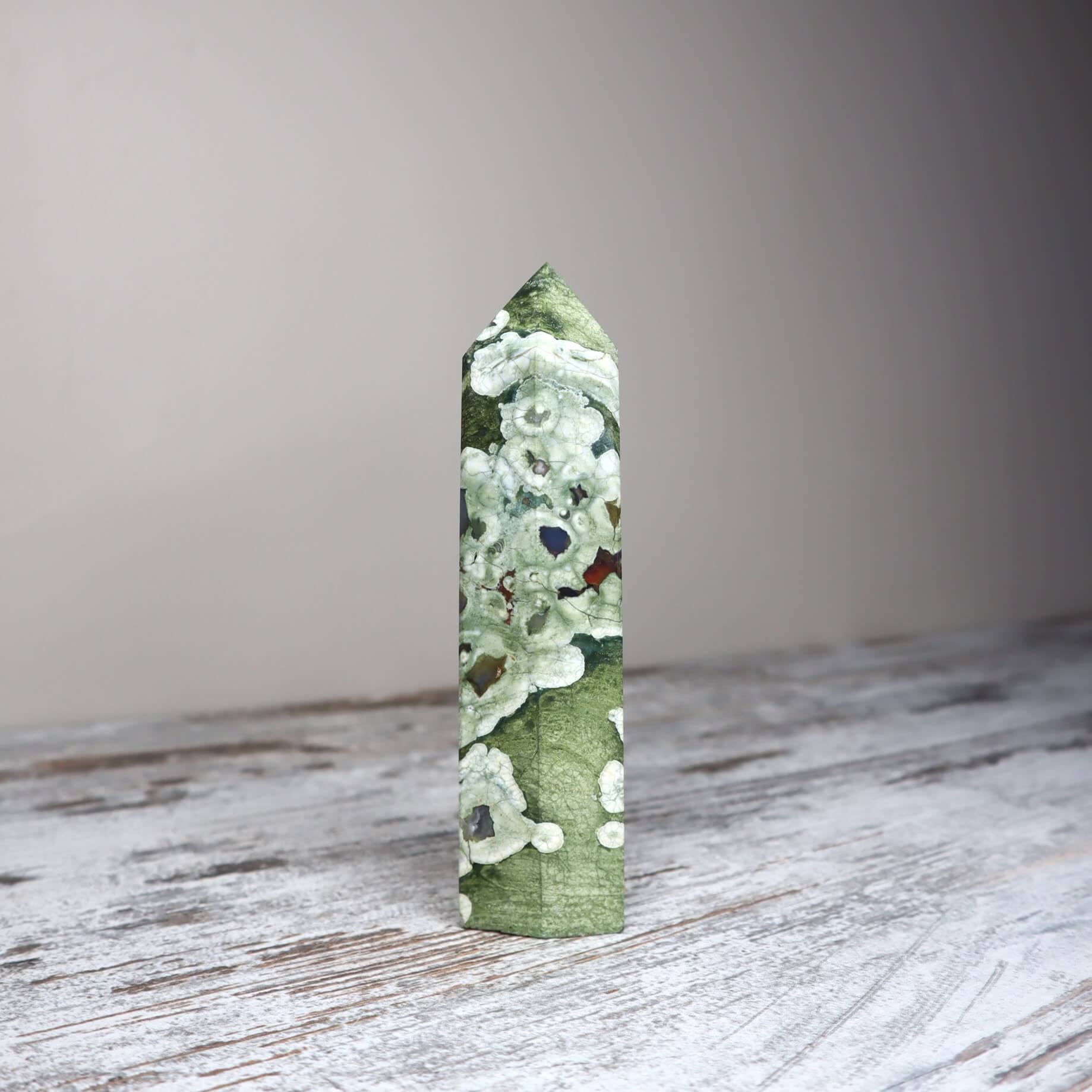 Polished Rainforest Jasper crystal point with lush green patterns for emotional healing.